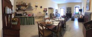 a living room with a dining table and a kitchen at B&B Al Caseificio in Barghe