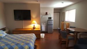 Habitación de hotel con cama, mesa y TV en Alpine Motel in heart of Wisconsin Dells downtown., en Wisconsin Dells