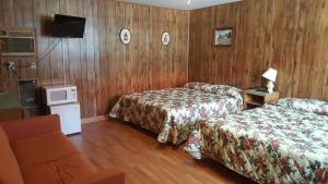 una camera d'albergo con due letti e una televisione di Alpine Motel in heart of Wisconsin Dells downtown. a Wisconsin Dells