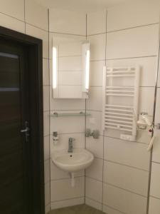 bagno bianco con lavandino e specchio di TESTO Apartments a Mielno