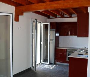 uma cozinha com tectos em madeira e uma cozinha com um frigorífico em Casa Nostos em Vasiliki