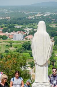 a group of people standing next to a statue at Hotel Tau in Međugorje