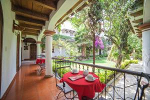 un balcone con tavolo e sedie rossi. di Hotel Jovel - Pago solo en efectivo a San Cristóbal de Las Casas