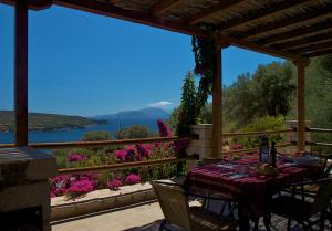 a table on a porch with a view of a lake at Casa Nostos in Vasiliki