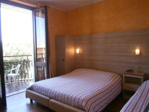 a bedroom with a bed and a balcony at Hotel Chiara in Sirmione