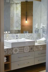 a bathroom with a sink and a mirror at AGA Tenis Apartments by Radwańska in Krakow