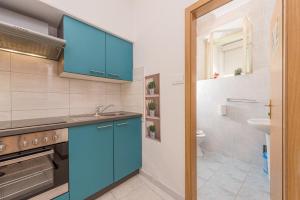Una cocina con gabinetes azules y un fregadero. en Apartment and Room Soul of Dalmatia, en Zadar 76 fotos más