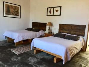 1 dormitorio con 2 camas y mesa con lámpara en Hacienda Santa Barbara Casa Malinche, en Huamantla