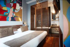 a bedroom with a bed and a painting on the wall at Boutique Hotel Saint-Géry in Brussels