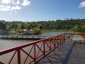 a red bridge over a river with a bench on it at Cond. Águas da Serra, Bananeiras in Bananeiras
