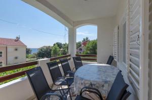 a patio with a table and chairs on a balcony at Apartments Caric in Ivan Dolac