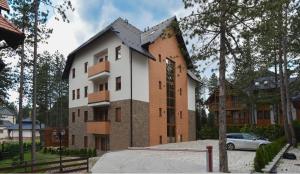 a building with a clock on the side of it at Lux Apartman Daria in Zlatibor