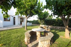 un banco de piedra en un patio con un árbol en Nuvolet Apartaments, en Cala en Blanes