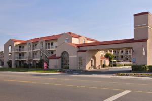 a building on the side of a street with a road at California Inn and Suites, Rancho Cordova in Rancho Cordova