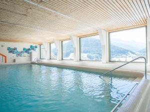 a large swimming pool with windows in a building at Spectacular View & Central Location in Davos in Davos