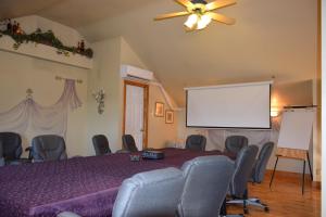 a conference room with a projection screen and chairs at Auberge Wild Rose Inn in Moncton