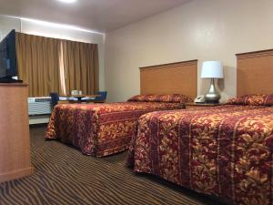 a hotel room with two beds and a television at Evergreen Lodge in Mount Shasta