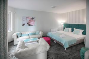 a bedroom with two beds and a couch at Villa Justyna in Pobierowo