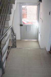 Una escalera que conduce a una puerta con una ventana. en Qosqo Tampu Apart Hotel, en Cusco