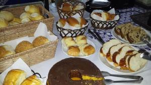 una mesa cubierta con bandejas de bollería en los platos en Pousada Ypê Amarelo, en Itatiaia