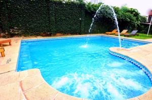 una piscina con una fuente en un patio en Hostería Casa Blanca Iguazú en Puerto Iguazú