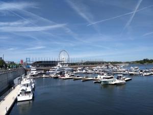 a bunch of boats docked in a harbor with a ferris wheel at Hotel Le Deville in Montreal