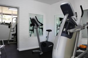 a gym with a treadmill and a mirror at The Oriana Orange - Retro Hotel & Resort in Orange