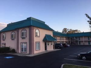 un edificio con un parcheggio di fronte a un hotel di Deluxe Inn a Galloway