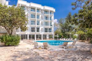 a hotel with a swimming pool and lounge chairs at Ekici Hotel in Kas