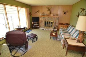 a living room with a couch and a fireplace at Lakeside Bills Bay Cabin in Namekagon