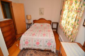 ein kleines Schlafzimmer mit einem Bett und einer Kommode in der Unterkunft Lakeside Bills Bay Cabin in Namekagon