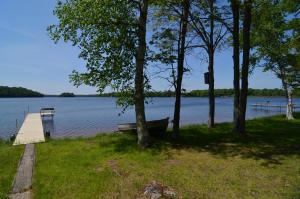 un barco a orillas de un lago con muelle en Lakeside Bills Bay Cabin, en Namekagon