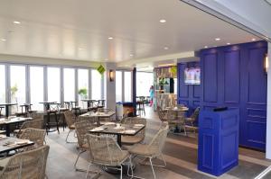 a restaurant with purple walls and tables and chairs at Suasana Residence JB City Lifestyle Suites by NEO in Johor Bahru