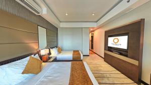 a hotel room with a bed and a flat screen tv at Mandarina Colombo in Colombo