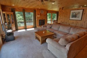 ein großes Wohnzimmer mit einem Sofa und einem TV in der Unterkunft Kenny Lodge Condo in Namekagon