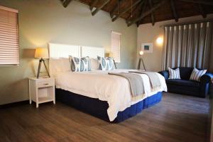 a bedroom with a large bed and a couch at Little Rock Guesthouse in Jongensfontein