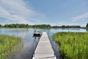 una barca è ormeggiata in un molo su un lago di Namakagon Landing Condo a Cable