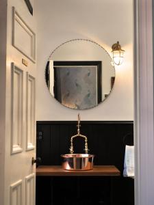La salle de bains est pourvue d'un lavabo et d'un miroir. dans l'établissement The Ferry Bed & Breakfast, à Queenstown