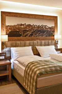 a bedroom with two beds and a painting on the wall at Hotel Alte Post in Fieberbrunn