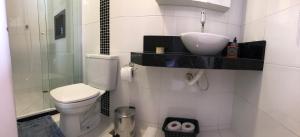 a bathroom with a toilet and a sink and a shower at Canto da Praia Suítes in Arraial do Cabo