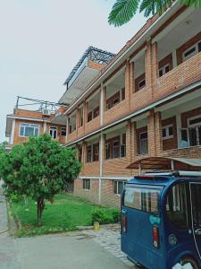 a blue van parked in front of a building at 行者之家SUNFLOWER in Lumbini