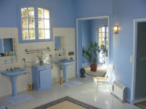 uma casa de banho com dois lavatórios e dois espelhos em Le Château d'Ailly em Parigny