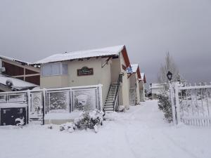 a house covered in snow with a fence at Las Victorias 3 in San Carlos de Bariloche