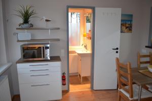 a kitchen with a microwave and a table with a table at Jana's Fewo in Lübeck