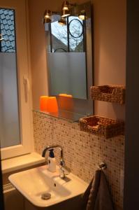 La salle de bains est pourvue d'un lavabo et d'un miroir. dans l'établissement Jana's Fewo, à Lübeck