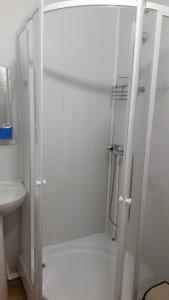 um chuveiro com uma porta de vidro na casa de banho em Motel MaksiM-4 DON em Pavlovsk