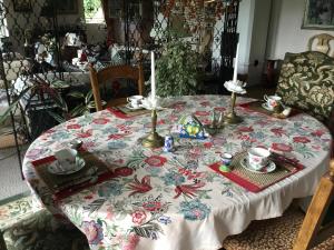 Fornuddens Bed and Breakfast في Tyresö: طاولة عليها قطعة قماش مزهرة
