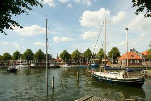 a boat docked in a marina with other boats at Vissershuisje / old fishermans house in Medemblik