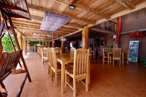 a dining room with a wooden table and chairs at Mario Hotel and Cafe in Weetebula