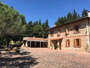 a large stone building with a brick courtyard at Agriturismo Testalepre in Greve in Chianti